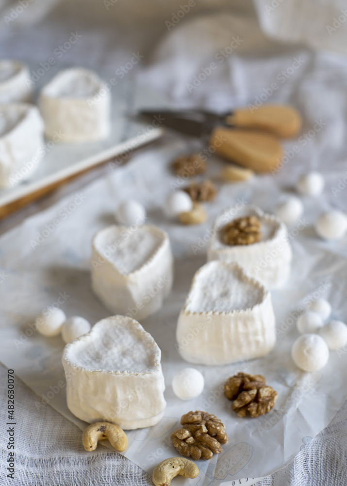 Heart-shaped cheese with white mold on wrapping paper. Home production, natural products. Heart-shaped cheese with white mold on wrapping paper. Home production, natural products.
