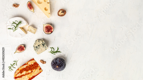 assortment of cheese, camembert, emmental, marble delicous cheese, blue cheese. Corner border of a selection of cheeses, figs, nuts and honey. place for text, top view