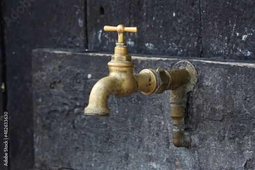 A close-up of a tap on the outside of a house
