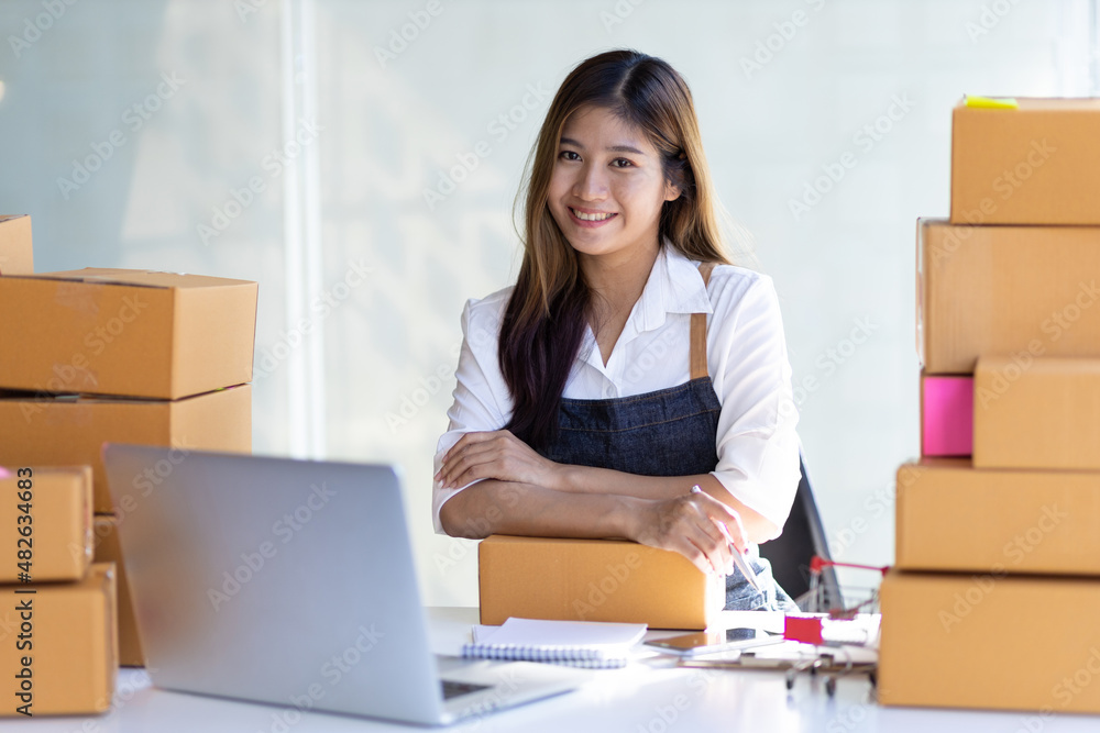 Asian woman starting a small business selling online. Asian woman starting a small business selling online.