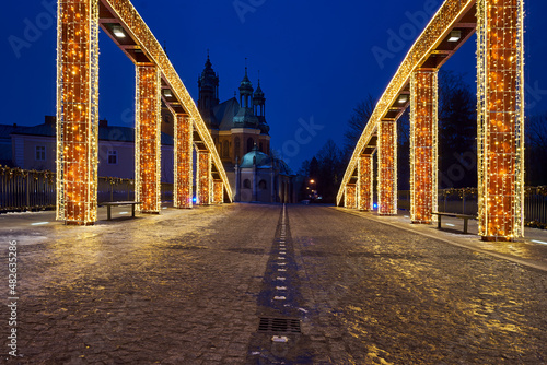 Christmas decorations on the steel structure of the bridge and towers of the Gothic cathedral at night