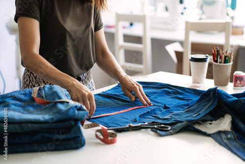 Mending Clothes  how to mend old Clothes. Sustainable fashion  Denim Upcycling Ideas  Using Old Jeans  Repurposing  Reusing Old Jeans  Upcycle Stuff. Woman seamstress cut and repair old blue jeans