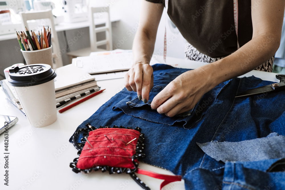 Mending Clothes, how to mend old Clothes. Sustainable fashion, Denim  Upcycling Ideas, Using Old Jeans, Repurposing, Reusing Old Jeans, Upcycle  Stuff. Woman seamstress cut and repair old blue jeans Stock Photo