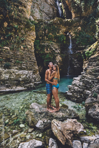 Young Couple in Hugging at Wild Waterfall