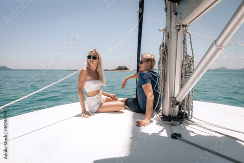Adorable shining pretty male and female models sitting on a yacht and discussing something very interesting enjoying moments and each other's company 
