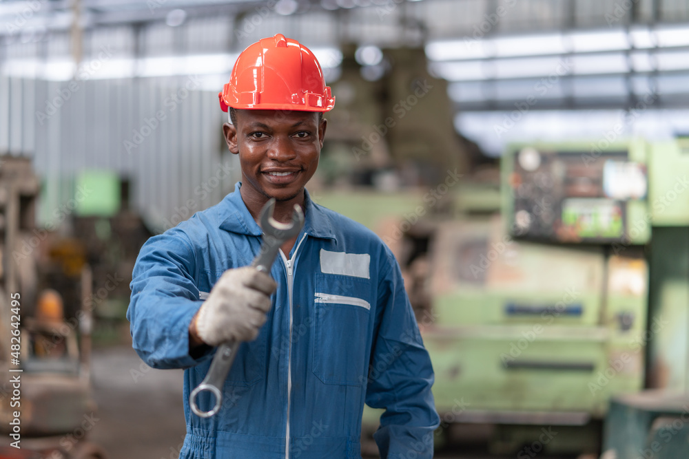 Portrait of engineer black worker wearing uniform safety with holding wrench tool stand in factory Portrait of engineer black worker wearing uniform safety with holding wrench tool stand in factory