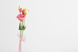 bouquet of eustoma in pink glass vase on white background