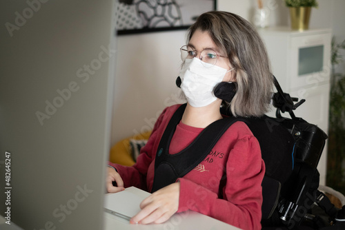 Disabled woman with muscular dystrophy working in front of a computer photo