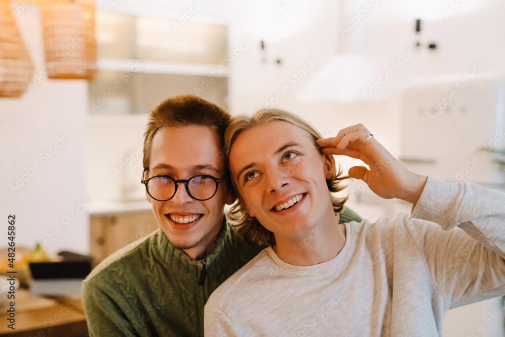Obraz premium European gay couple hugging and smiling while spending time together