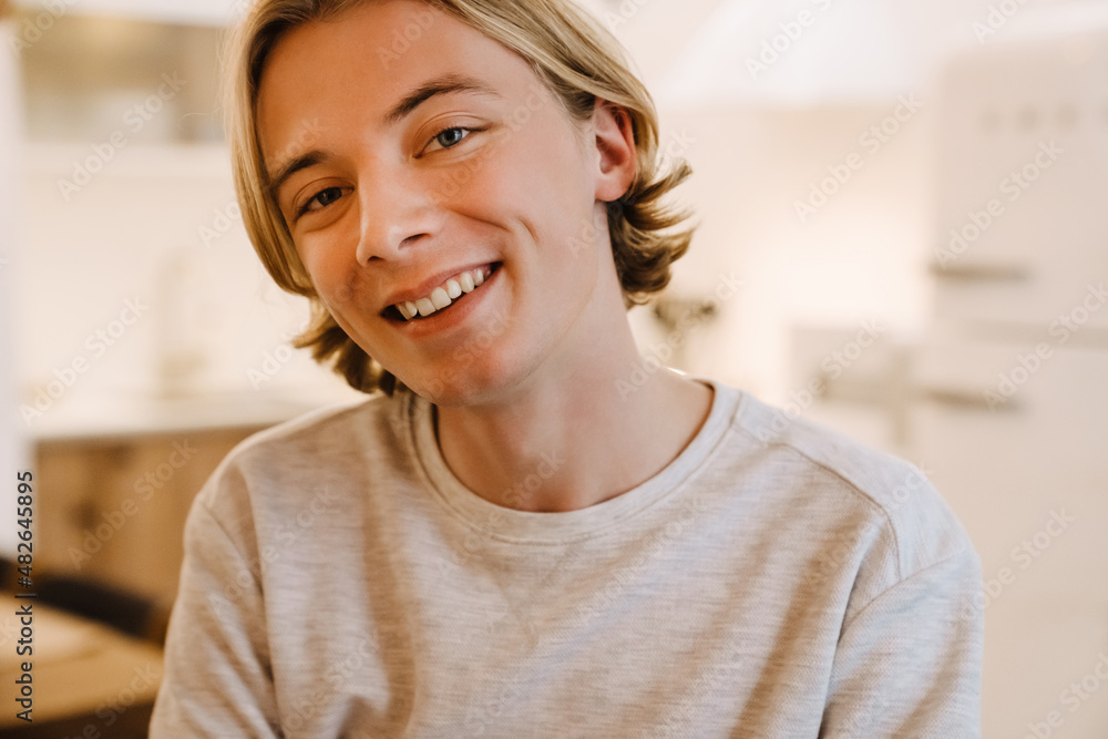 European blonde man smiling and looking at camera in home