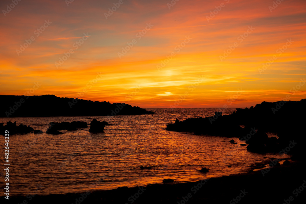 Fototapeta premium Cala Viola de Ponent, Menorca. September 2021. Magnificent sunset in the Mediterranean Sea. On one of the paradisaical beaches of the island of Menorca.