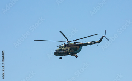 The military helicopter against the blue sky