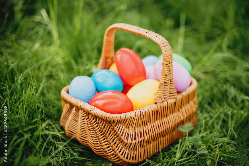 Colorful easter eggs in basket on green grass outdoor. Easter background concept. egg hunt. Colorful easter eggs in basket on green grass outdoor. Easter background concept. egg hunt.