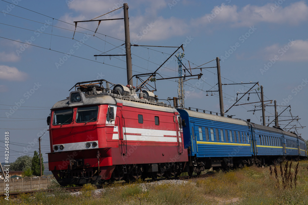 The locomotive moves on a track on a clear summer day