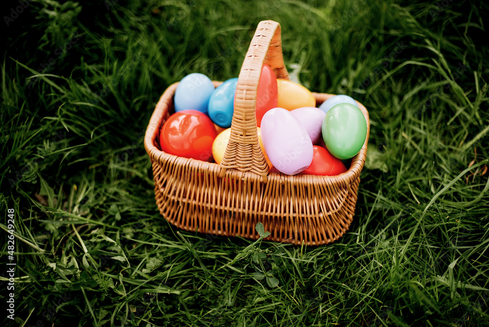 Colorful easter eggs in basket on green grass outdoor. Easter background concept. egg hunt. Colorful easter eggs in basket on green grass outdoor. Easter background concept. egg hunt.