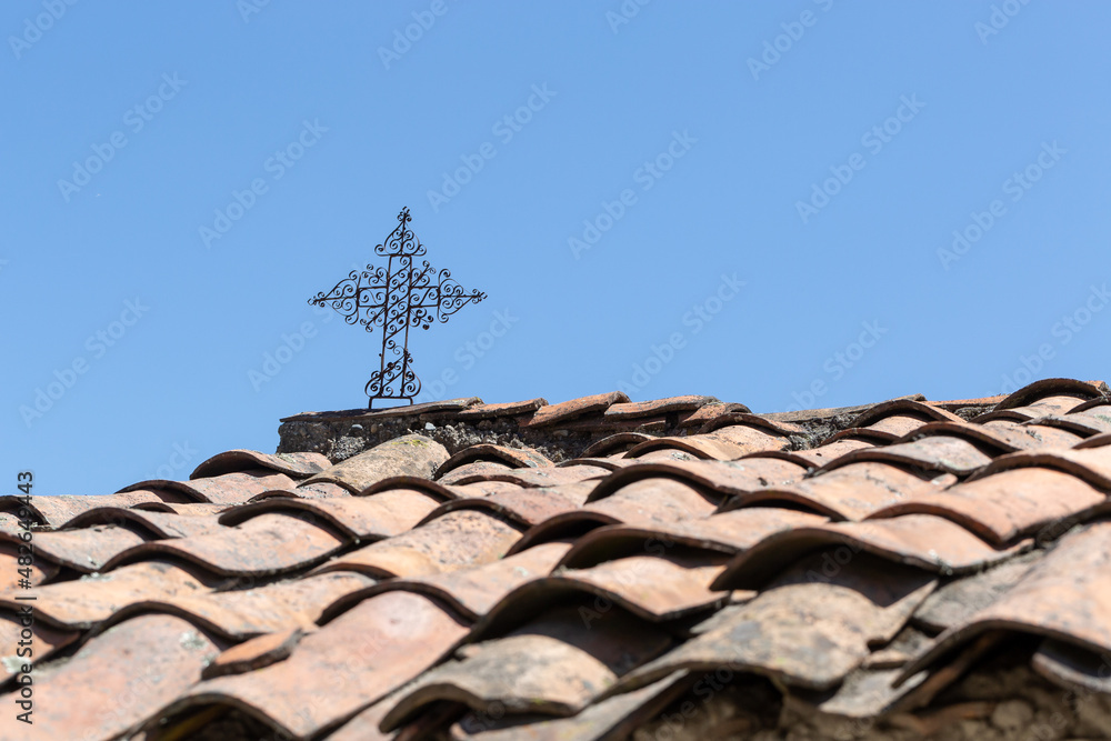 A small iron cross on the roof of a house in the Andes A small iron cross on the roof of a house in the Andes