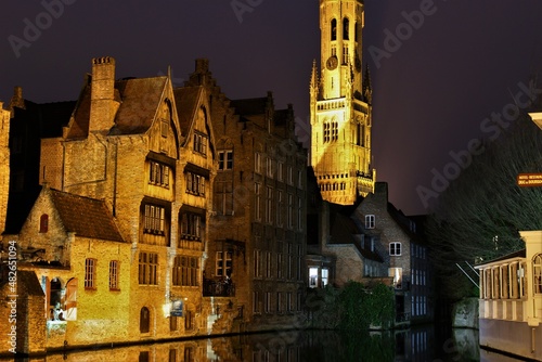 Bruges canals in winter at night with view of the Belfry (Belgium). Wallpaper or travel background.