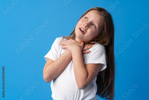 Shocked little girl looking with amazement on blue background