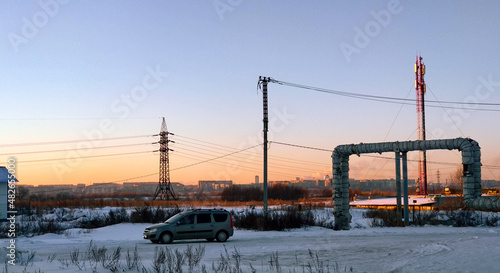 Car against the backdrop of an industrial winter countryside landscape in Russia