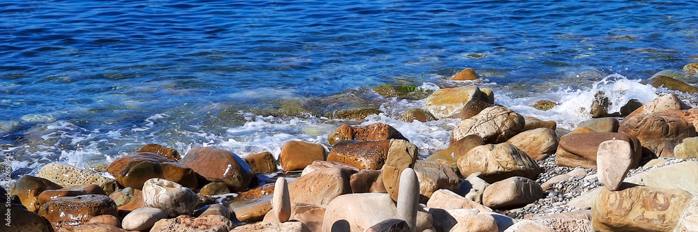 Obraz premium Coast with large stones in the sea water,soft focus. Panoramic natural background.