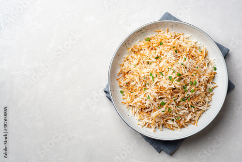 Rice with vermicelli in plate on concrete background. Traditional arabic dish.
