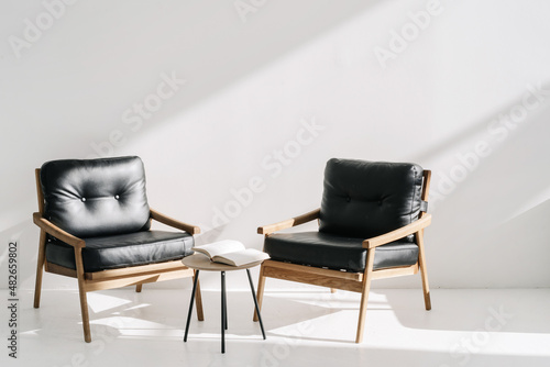 Billede på lærred Two leather armchairs standing near coffee table