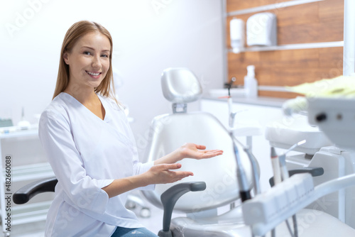 Smiling stomatologist invents to sit in chair