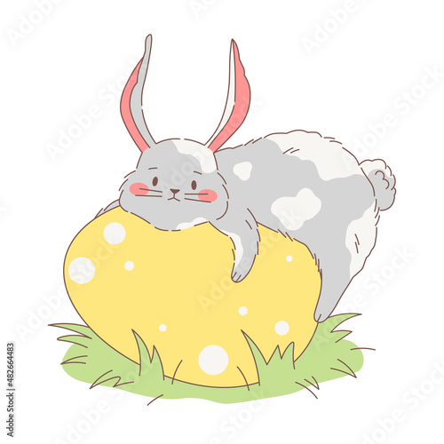 Cute fluffy bunny lies and hugs a big Easter egg. Vector illustration of a chubby hand drawn grey and white rabbit. Cartoon sweet style design.
