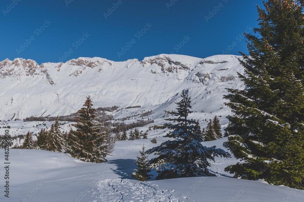 Fototapeta premium A picturesque landscape view of the snowcapped French Alps mountains with a hiking path in the snow on a cold winter day (Devoluy)