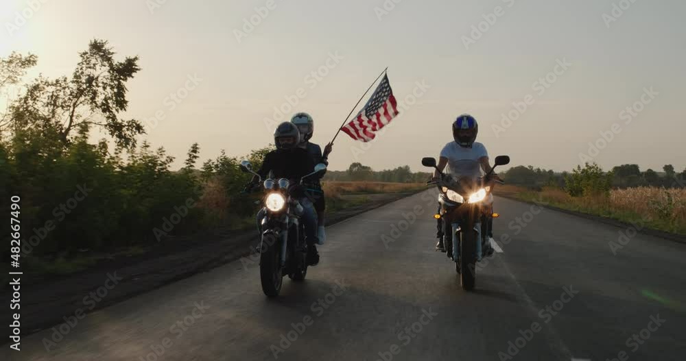 Young people travel on motorcycles with the U.S. flag Young people travel on motorcycles with the U.S. flag