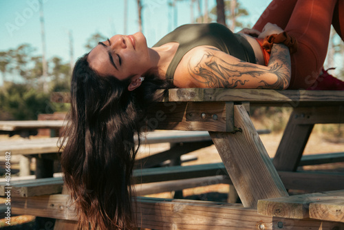 Spanish young woman lying on a table in a park.
