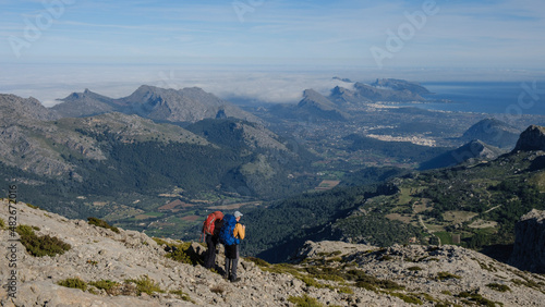 two hikers looking Alcudia and Pollensa bays from the Sierra de Tramuntana, Escorca, Mallorca, Balearic Islands, Spain