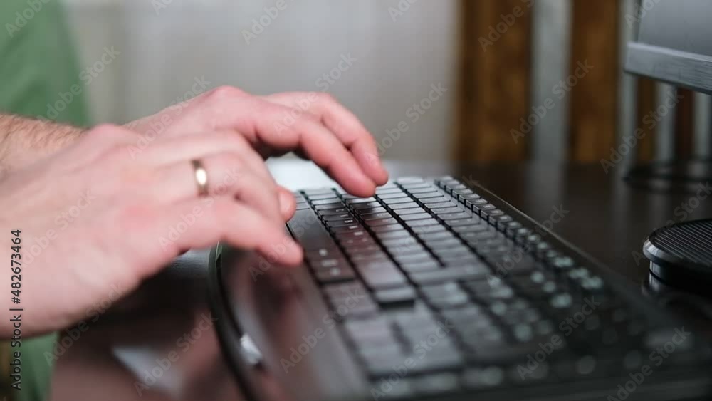 Man's hand prints on the keyboard. Correspondence, work at home. An engagement ring is on her finger. Man's hand prints on the keyboard. Correspondence, work at home. An engagement ring is on her finger.