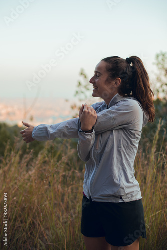 Girl doing stretching before running session outdoors