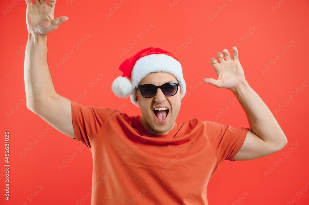 Portrait of happy and excited man in santa hat, rejoicing and winning something, celebrating new year, standing over red background Portrait of happy and excited man in santa hat, rejoicing and winning something, celebrating new year, standing over red background