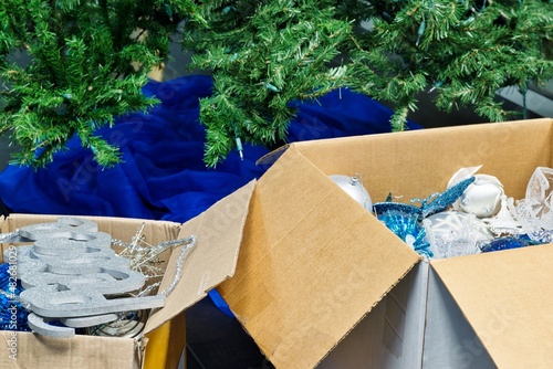 Packing away Christmas decorations after new year full box decorations by empty tree and skirt.	