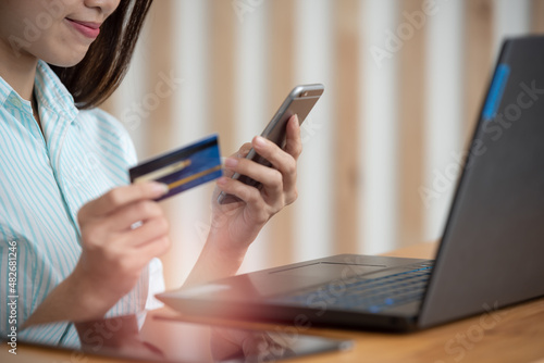 Woman holding credit card and using laptop for online shopping