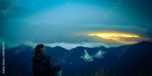 woman watching the sunrise on top of the mountain
