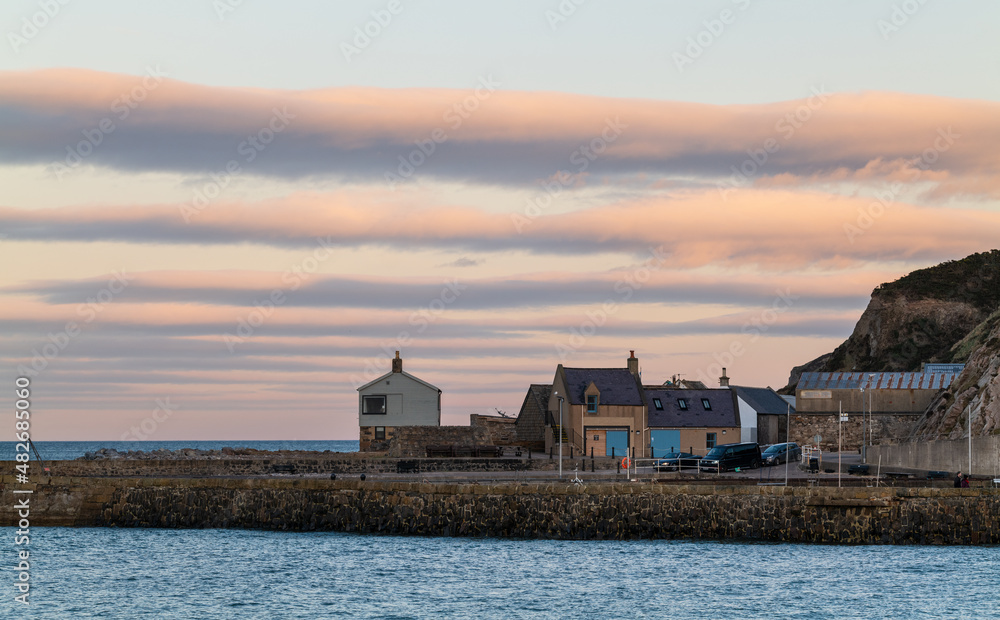 CULLEN, MORAY, SCOTLAND - 23 JANUARY 2022: This is the lines of cloud getting the last rays of the sun in Cullen, Moray, Scotland on Sunday 23 January 2022.
