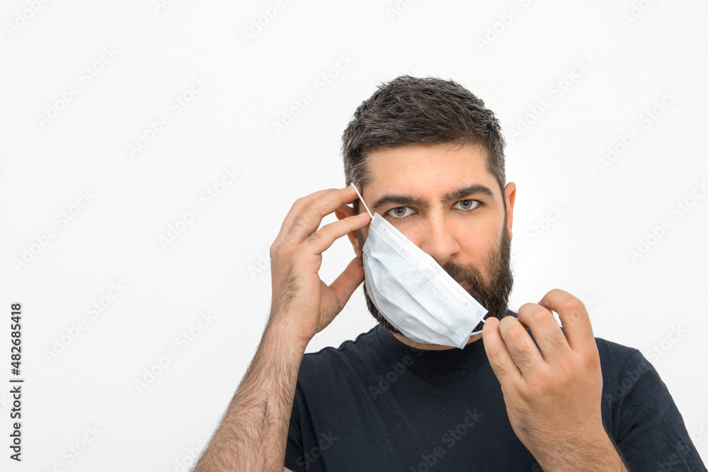 A young man with a beard and masks. Security measures. Masked man. Isolated background. A young man with a beard and masks. Security measures. Masked man. Isolated background.