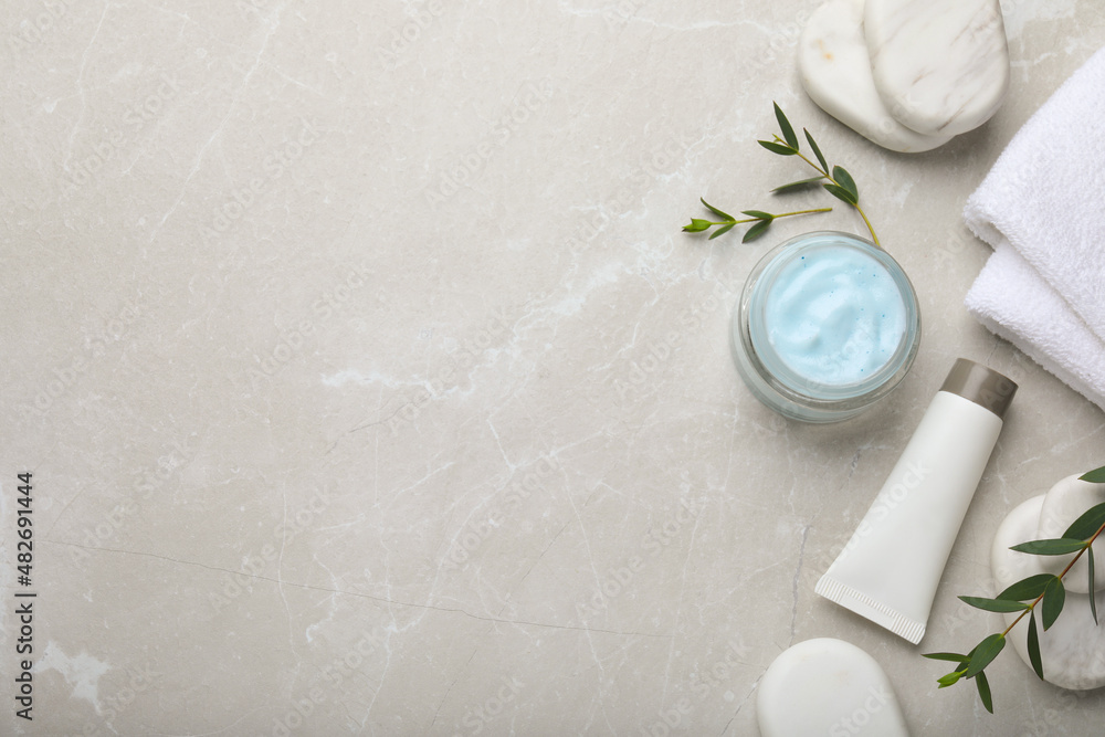 Flat lay composition with jar of organic cream and spa stones on light marble table. Space for text Flat lay composition with jar of organic cream and spa stones on light marble table. Space for text