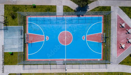 Multisport court seen at 90 degrees from a drone in blue and red colors, where you can see the markings for football and basketball games.
