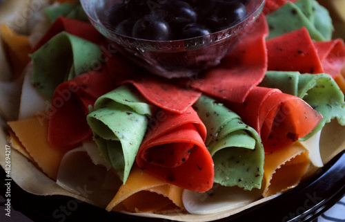 beautiful multicolored cheese plate with dark grapes