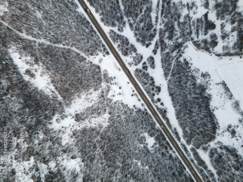 High angle top down aerial view drone image on road trough the trees and forest in mountain range covered with white snow in winter day near Knjazevac in Serbia car Travel journey and vacation concept © Miljan Živković