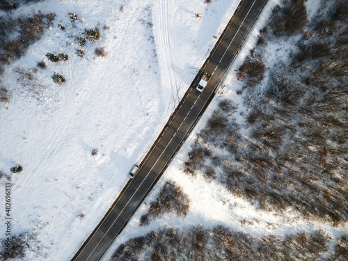 High angle top down aerial view drone image on road trough the trees and forest in mountain range covered with white snow in winter day near Knjazevac in Serbia car Travel journey and vacation concept