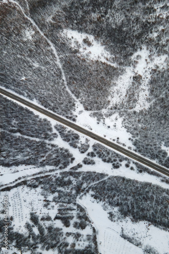 High angle top down aerial view drone image on road trough the trees and forest in mountain range covered with white snow in winter day near Knjazevac in Serbia - Travel journey and vacation concept © Miljan Živković