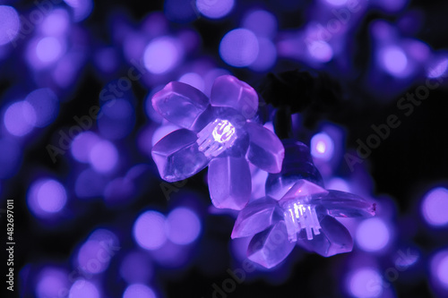 purple garlands in the form of flowers, christmas lights macro photo abstract background
