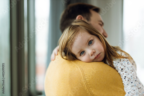 Fotografie Cute little girl embracing her father by the window
