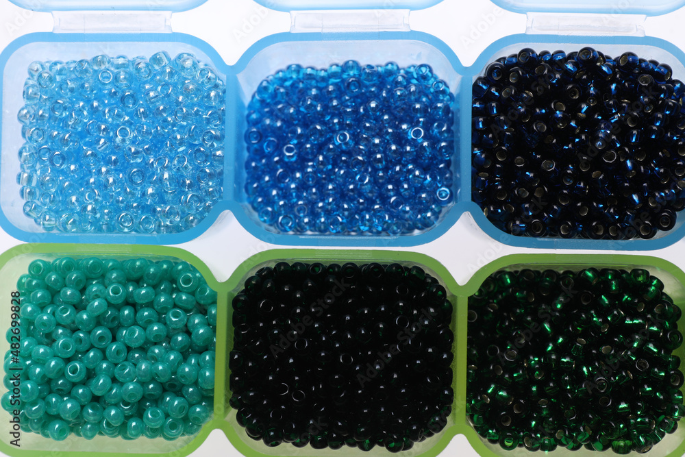 Plastic organizers with different beads on white background, top view Plastic organizers with different beads on white background, top view