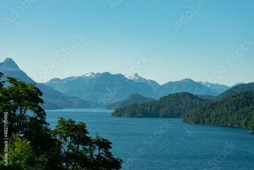 lago de agua color azul y celeste con arboles y montaña